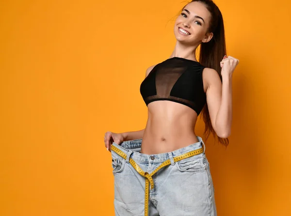Beautiful young woman with big jeans — Stock Photo, Image