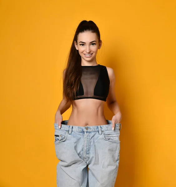 Beautiful young woman with big jeans — Stock Photo, Image