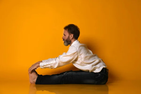 Viejo hombre practica Ashtanga Vinyasa yoga espalda flexión asana Paschimottanasana - sentado hacia adelante curva — Foto de Stock