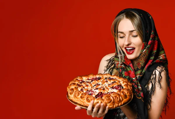 Retrato de uma jovem bela loira em lenço de cabeça segurando uma deliciosa torta de baga caseira. — Fotografia de Stock