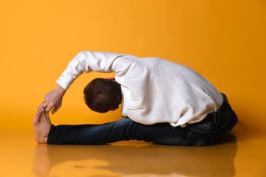 Yaşlı adam Ashtanga Vinyasa yogası yapıyor geriye doğru eğilerek asana Paschimottanasana - öne doğru eğiliyor.