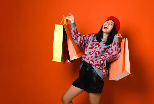 Een mooie jonge vrouw stijlvol gekleed in een hoed met tassen na het winkelen — Stockfoto