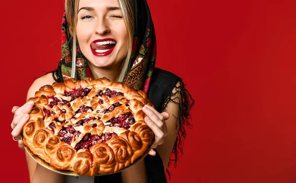 Retrato de uma jovem bela loira em lenço de cabeça segurando uma deliciosa torta de baga caseira. — Fotografia de Stock