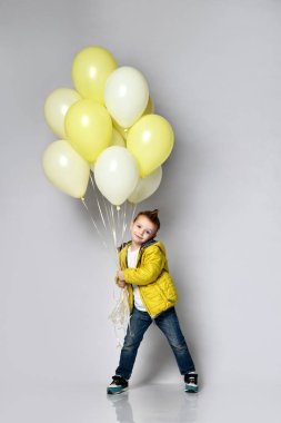 Beyaz balon tutan şık küçük çocuk.