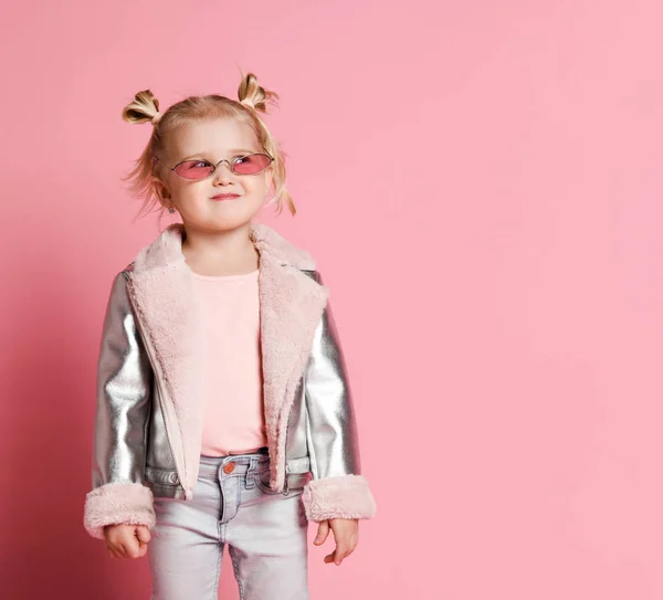 Retrato de una niña con ropa elegante posando sobre fondo rosa y jugando — Foto de Stock