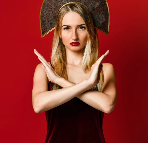 Mulher mostrando um braço parado cruzado. Em um fundo vermelho. — Fotografia de Stock