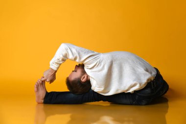 Yaşlı adam Ashtanga Vinyasa yogası yapıyor geriye doğru eğilerek asana Paschimottanasana - öne doğru eğiliyor.