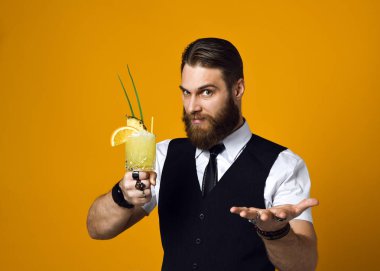 Sakallı sakallı barmen yeleğinde kokteyl tutuyor.