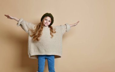 Örgü şapka ve kazak giyen mutlu küçük kız kış portresi.