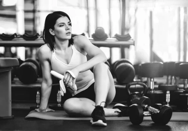 Молода спортивна жінка має перерву в тренуванні в тренажерному залі. робить закуску бананом . — стокове фото