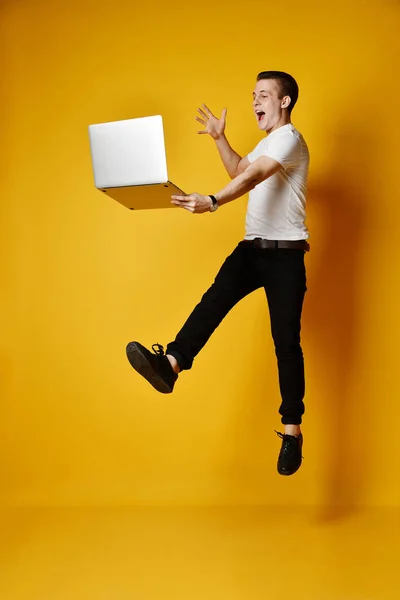 Estudiante saltando con portátil — Foto de Stock