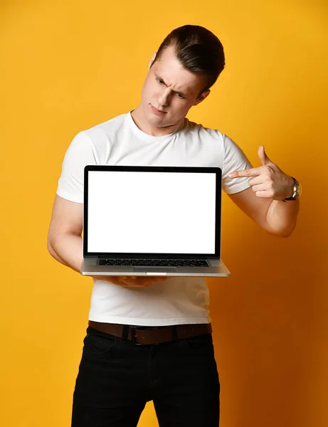 Un joven guapo sosteniendo y mostrando la pantalla de un portátil — Foto de Stock