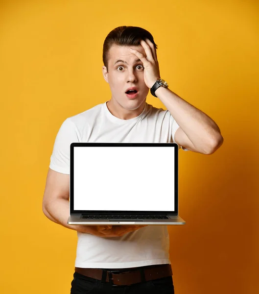 Un joven guapo sosteniendo y mostrando la pantalla de un portátil — Foto de Stock