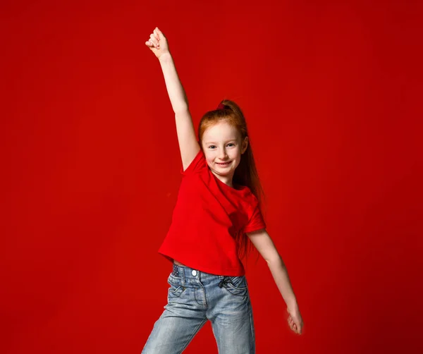 Portret van een jong meisje met rood haar glimlachend naar de camera met handen in de lucht — Stockfoto