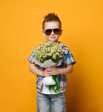 Elinde bir buket çiçek tutan sevimli küçük çocuk..