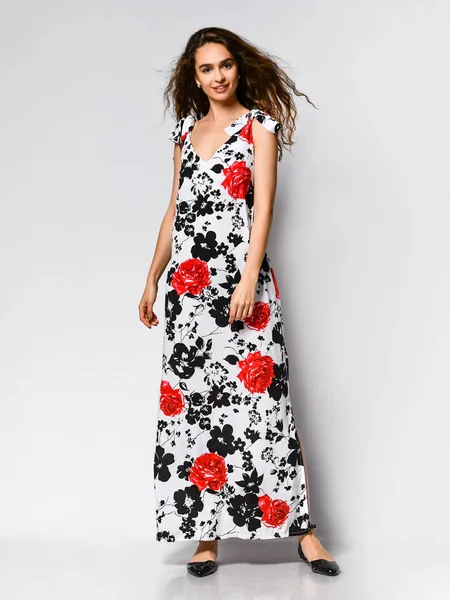 Jovem bela mulher posando em novo vestido de moda padrão de flor vermelha no fundo branco. Moda primavera verão foto — Fotografia de Stock