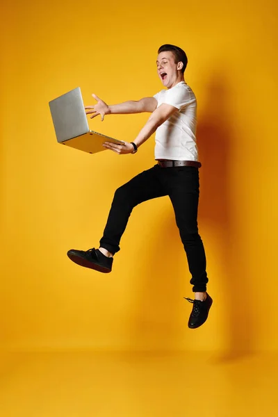 Estudiante saltando con portátil — Foto de Stock