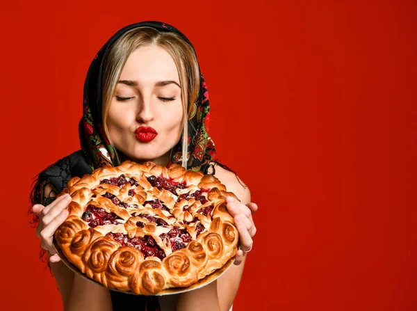 Portrait of a young beautiful blonde holding a delicious homemade cherry pie. — Stock Photo, Image