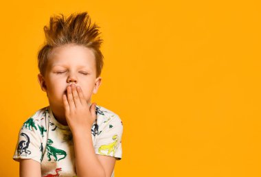 sarı arka plan üzerinde izole beyaz gömlek küçük esneme çocuk