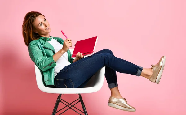 Young woman studying whith notepad in a chair — Stock Photo, Image