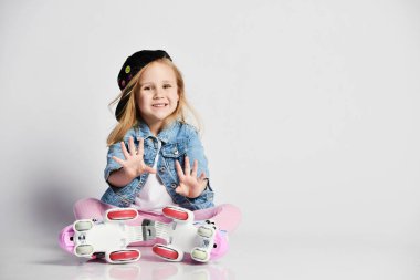 kız mavi bir kot ve kap içinde silindirler üzerinde oturur ve gülümsüyor. Çocuklar için yaz sporları.