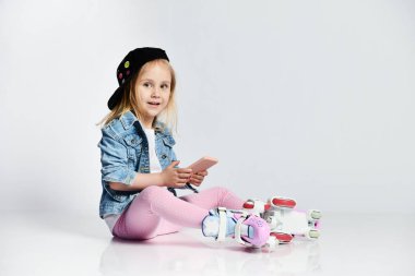 kız mavi bir kot ve kap içinde silindirler üzerinde oturur ve gülümsüyor. Çocuklar için yaz sporları.