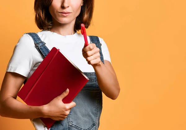 Pretty young beautiful woman standing, take notes, holding textbook notebook organizer in hand and pen — Stock Photo, Image