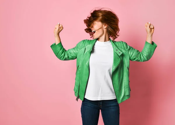 Woman wearing jeans and a jacket is shaking her head with her hair. The concept of joy, happiness, joy, fun — Stock Photo, Image