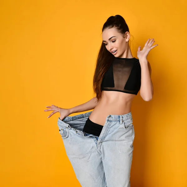 Beautiful young woman with big jeans — Stock Photo, Image