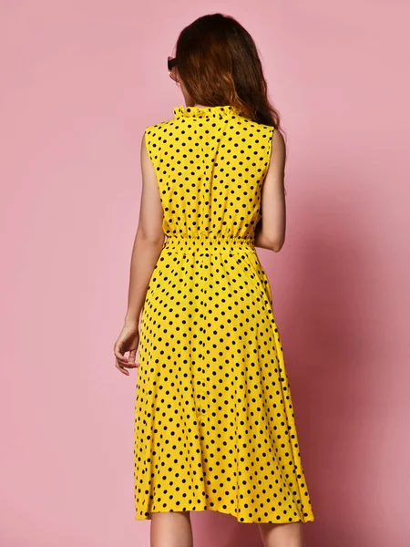 보라색 배경에 예쁜 미소 로맨틱 한 드레스에 아름다운 소녀. 노란 물방울 무늬 드레스를 입은 날씬한 곱슬 여성 모델 — 스톡 사진