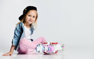 kız mavi bir kot ve kap içinde silindirler üzerinde oturur ve gülümsüyor. Çocuklar için yaz sporları.