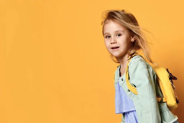 Full längd porträtt av en söt liten barnflicka i en snygg klänning och denim. — Stockfoto