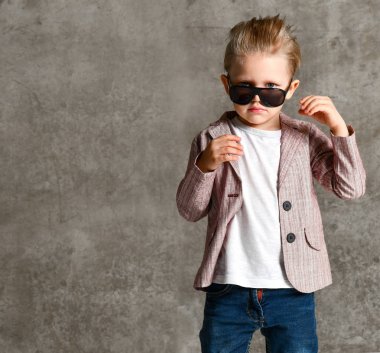 Neşeli, heyecanlı küçük bir çocuğun beton duvarın üzerinde tek başına duruşu..