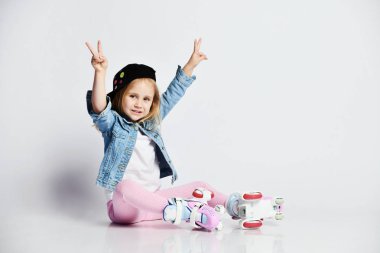 kız mavi bir kot ve kap içinde silindirler üzerinde oturur ve gülümsüyor. Çocuklar için yaz sporları.