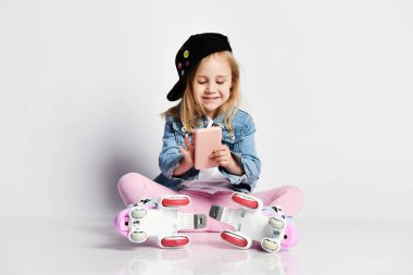 kız mavi bir kot ve kap içinde silindirler üzerinde oturur ve gülümsüyor. Çocuklar için yaz sporları.