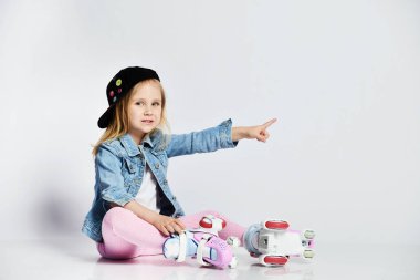 kız mavi bir kot ve kap içinde silindirler üzerinde oturur ve gülümsüyor. Çocuklar için yaz sporları.