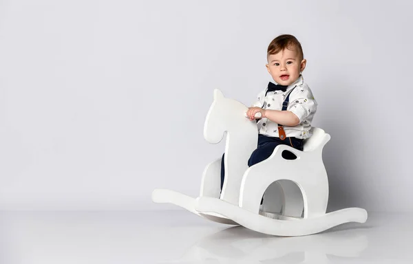 Funny baby sitting on the toy horse — Stock Photo, Image