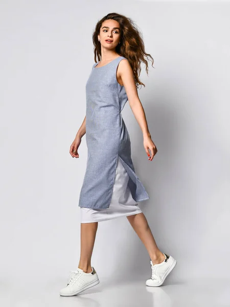Retrato de una joven morena en un vestido de luz azul posando sobre un fondo claro, moda de verano, preparándose para una cita —  Fotos de Stock