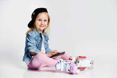 kız mavi bir kot ve kap içinde silindirler üzerinde oturur ve gülümsüyor. Çocuklar için yaz sporları.