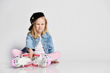 kız mavi bir kot ve kap içinde silindirler üzerinde oturur ve gülümsüyor. Çocuklar için yaz sporları.