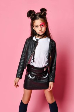 Elbiseli, uzun siyah saçlı güzel bir kız yıldız ve bulut şeklinde pembe balonlar tutuyor ve pembe bir arka planda kameraya bakıyor.