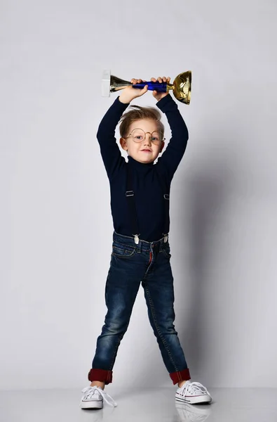 Mały chłopiec obchodzi jego złote trofeum — Zdjęcie stockowe