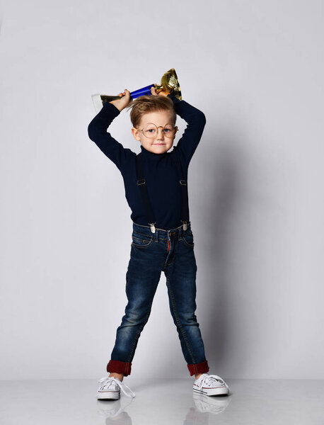 Мальчик празднует свой золотой трофей
