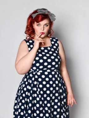 Kızıl saçlı kadını sabitle. Güzel Retro kadın Polka kırmızı dudaklar ve manikür çivi ve eski moda saç modeli ile elbise nokta