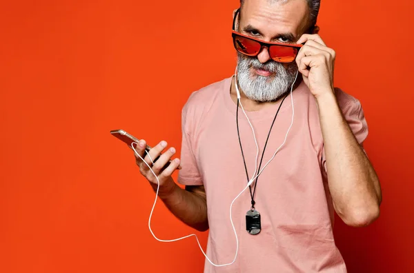 Uma imagem de um idoso ouvindo música com fones de ouvido — Fotografia de Stock