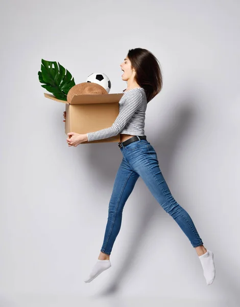 Young woman holding box with things.