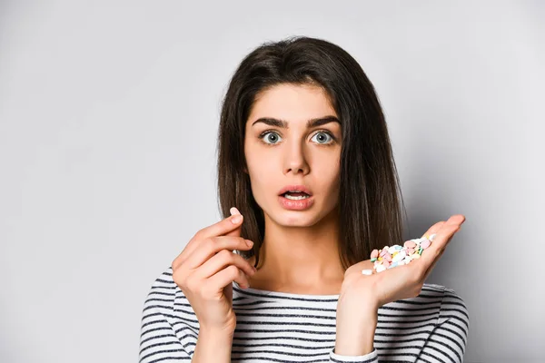 Surprised young woman is indignant that she can drink so many different pills