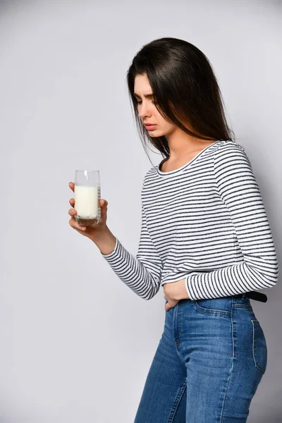Olycklig ung kvinna dricker mjölk — Stockfoto