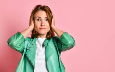 Güzel üzgün kadın poz, kulakları kapsayan duvar açık pembe arka plan üzerinde izole