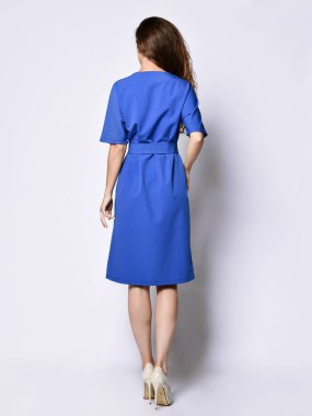 Tam büyüme mavi bir kentsel elbise ince kıvırcık kadın modeli. Romantik kıyafetler giyen güzel kız randevuya gider, ofise, toplantıya. Kentsel moda